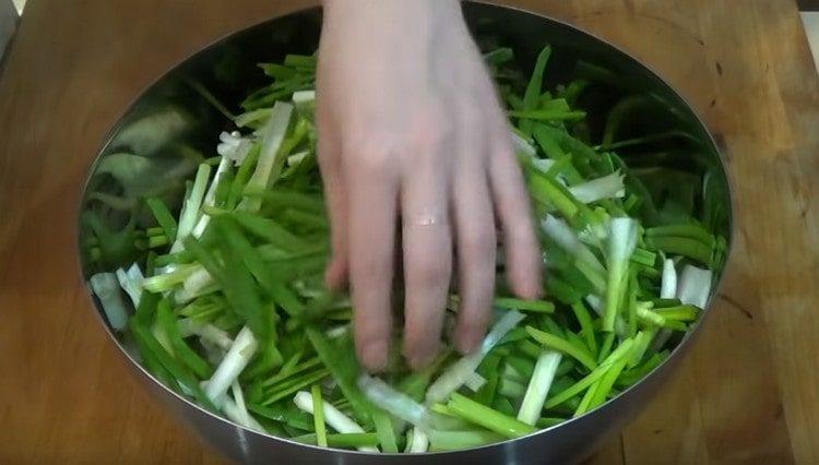 Tritare le cipolle verdi, aggiungere a daikon.