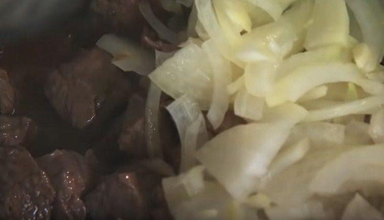 Aggiungi la cipolla con l'aglio alla carne.