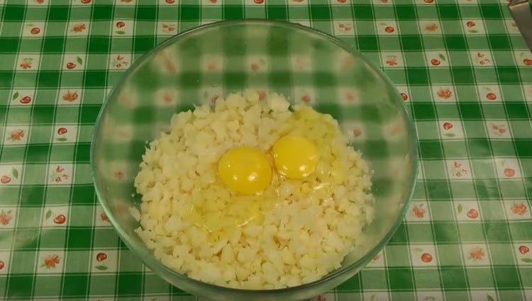 Fügen Sie zwei Eier der Kohlmasse hinzu, Salz, um zu schmecken.