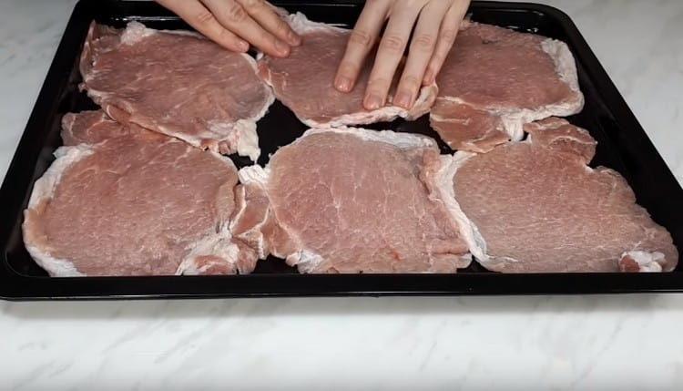 Mėsos gabalėlius dėkite ant kepimo popieriumi išklotos skardos.