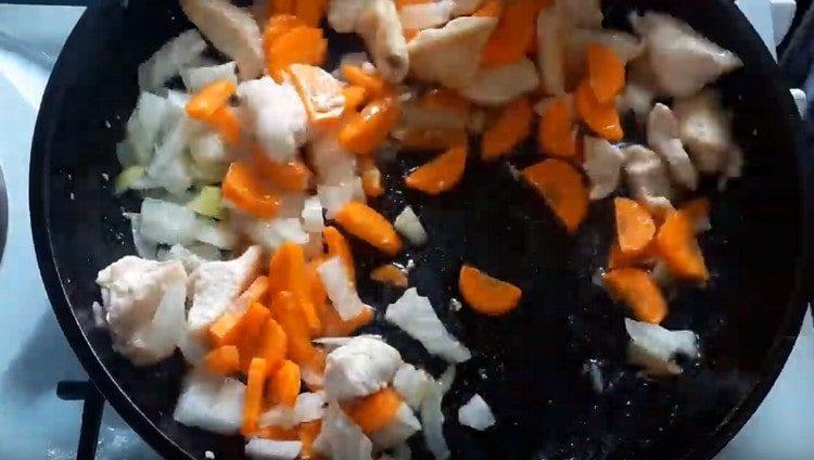 Lisää porkkanat sipulien kanssa pannulle kanalle.
