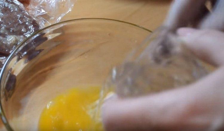 Sbattere l'uovo con un cucchiaio d'acqua separatamente.