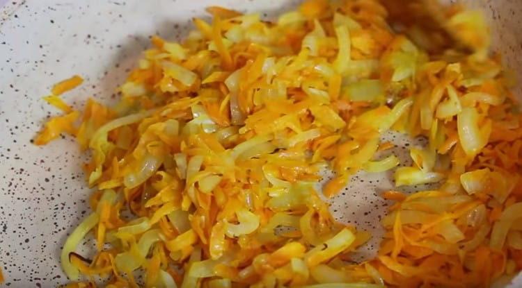 Friggere le cipolle con le carote in olio vegetale fino a renderle morbide.