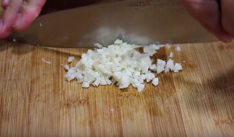 Tritare finemente l'aglio.