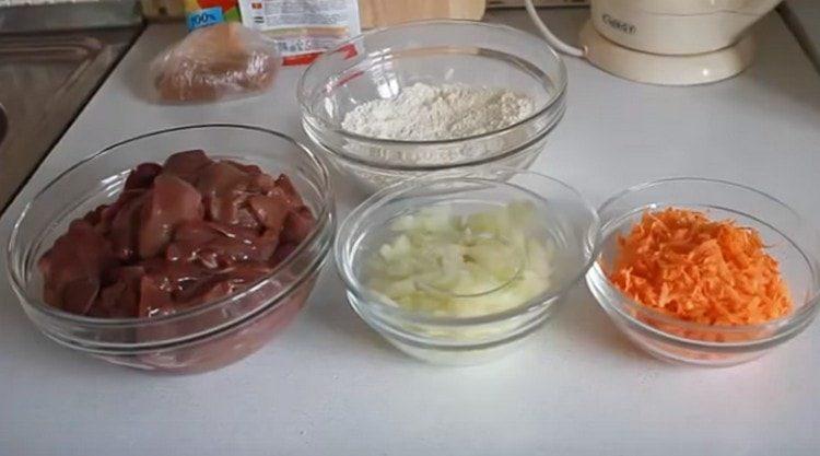 Wir schneiden die Leber in Stücke, wir schneiden auch die Zwiebeln, drei Karotten auf einer Reibe.