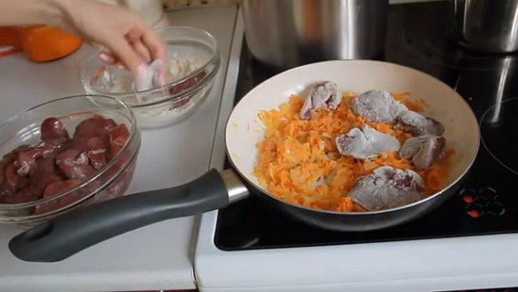Κομμάτια από συκώτι σε αλεύρι και απλώνονται σε ένα τηγάνι για τα λαχανικά.