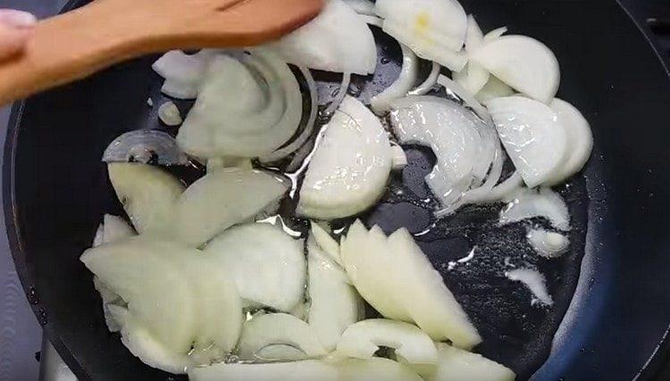 In una padella, friggere la cipolla tagliata a metà anelli.