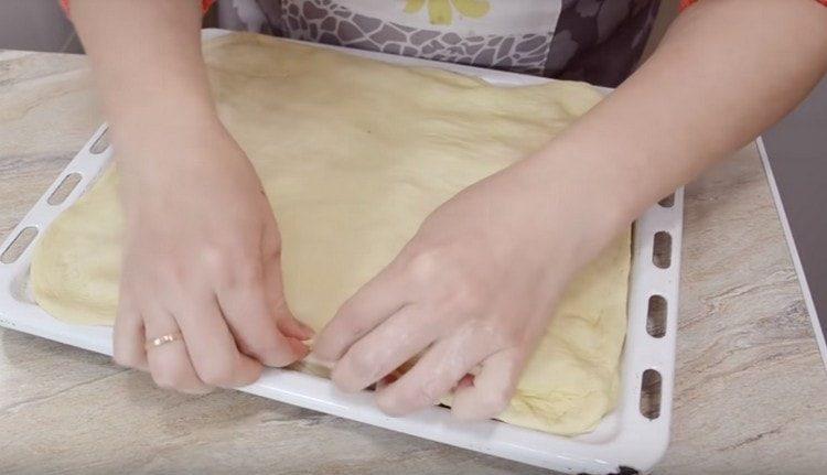 stendere il secondo pezzo di pasta, coprirli con il ripieno e pizzicare i bordi.