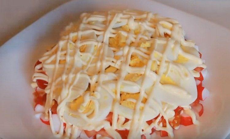 Ant pomidorų dedame kiaušinių gabaliukus, sutepame juos majonezu.