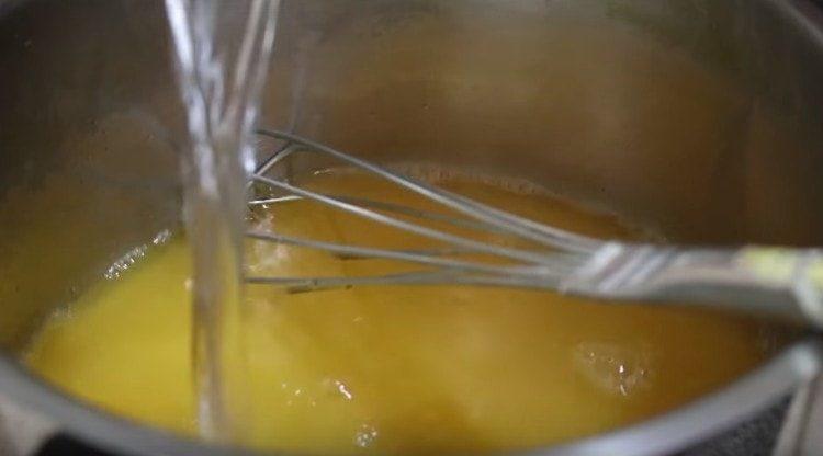 Изсипете портокаловия сок и водата в яхнията.