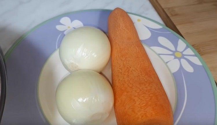 Eine Karotte und zwei Zwiebeln schälen.