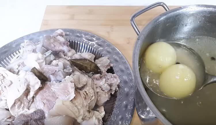 Wir nehmen das Fleisch vom gekochten gelierten Fleisch heraus, werfen die Zwiebel heraus.