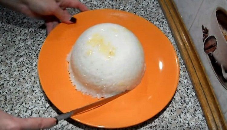 Copri la carne con il riso rimasto e gira la ciotola sul piatto da portata.