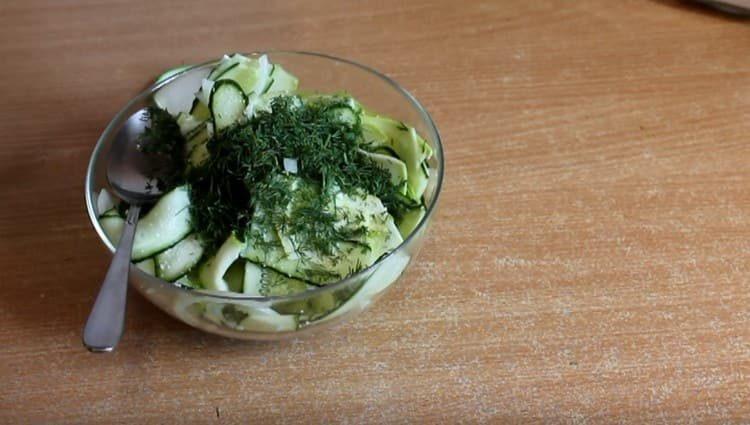 Den Salat salzen, das Gemüse dazugeben.