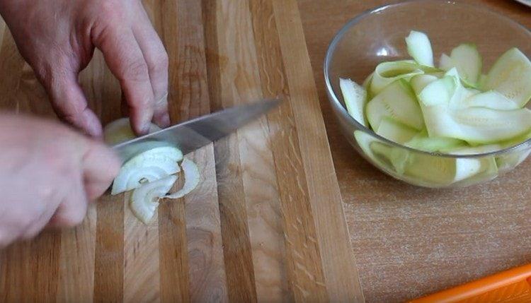 Wir schneiden die Zwiebel in dünne Halbringe.