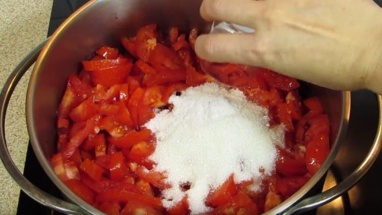 Слагаме доматите в тиган, добавяме към тях сол и захар.