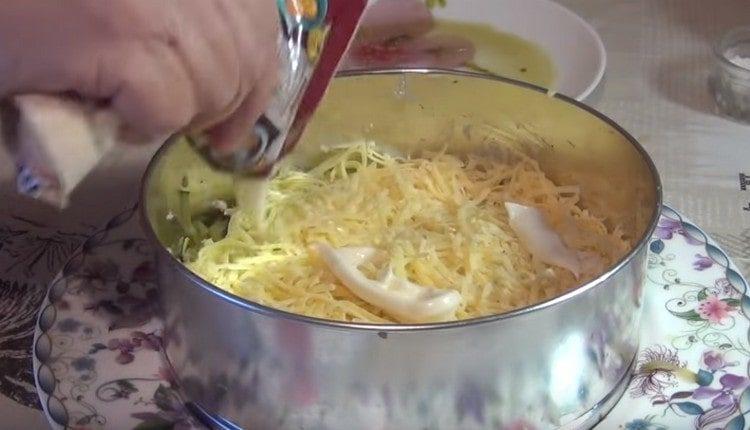 Preparare uno strato di formaggio, ungere con maionese.