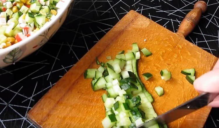 Нарежете краставицата и добавете към салатата.