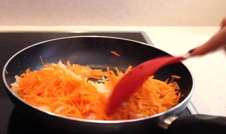 Добавете настърганите моркови към лука.
