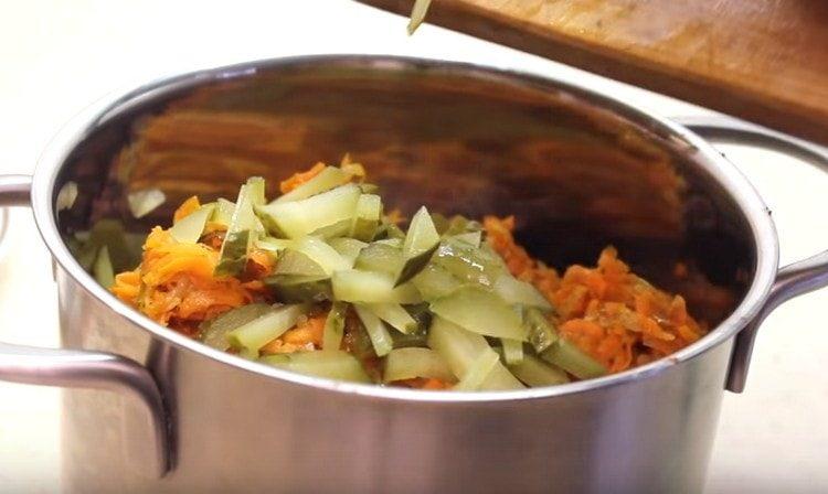 Нарежете киселите краставици на ивици и добавете към салатата.