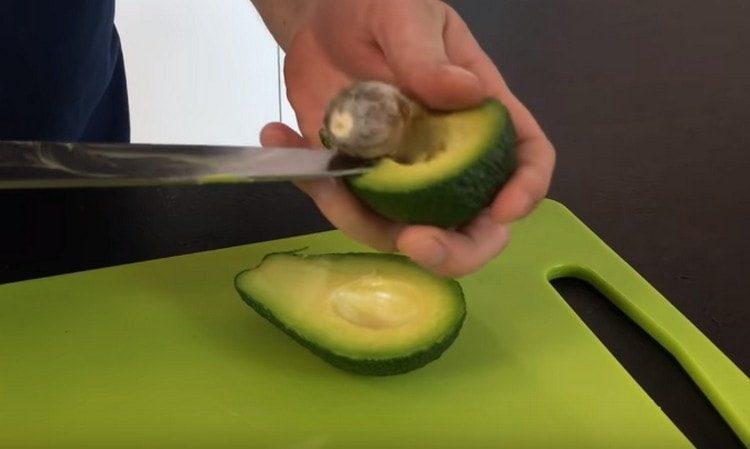 Tagliare l'avocado a metà e rimuovere la pietra.