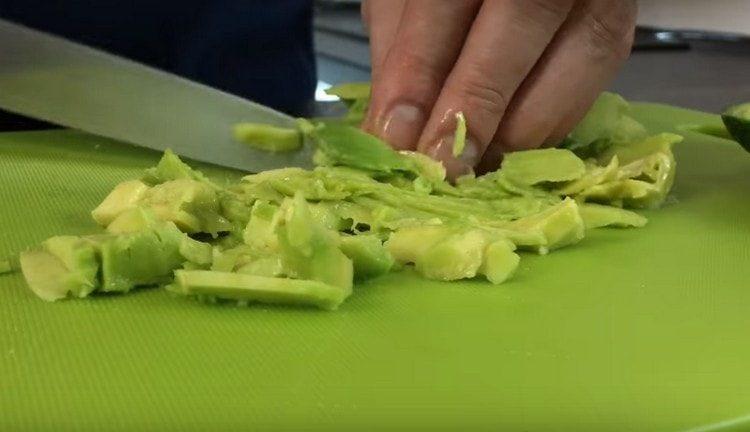 Taglia la polpa di avocado, aggiungi l'insalata.