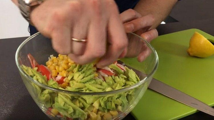 Avocado in einen Salat mit Zitronensaft streuen.
