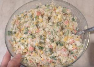 Prepariamo un'insalata delicata con bastoncini di granchio e riso secondo una ricetta passo-passo con una foto.
