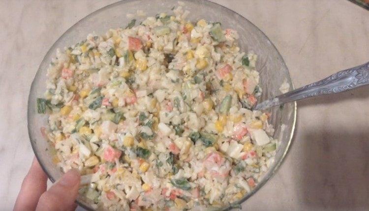 Qui abbiamo un'insalata così deliziosa con bastoncini di granchio e riso.