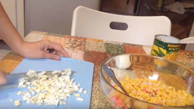 Нарежете варените яйца и добавете към салатата.
