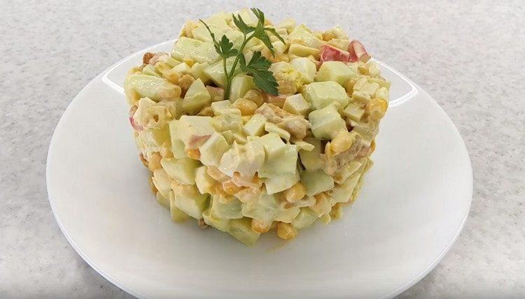 tale insalata con bastoncini di granchio e cracker può essere servita magnificamente, decorata con un anello di pasta.