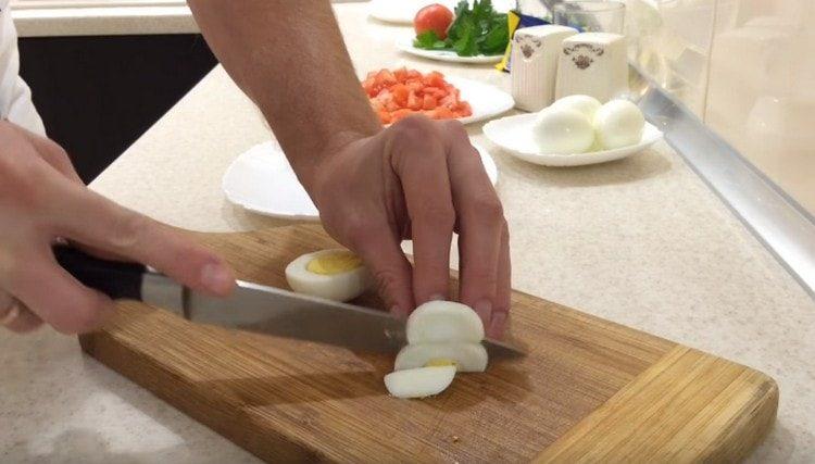 Твърдо сварените яйца се нарязват на половин пръстени.