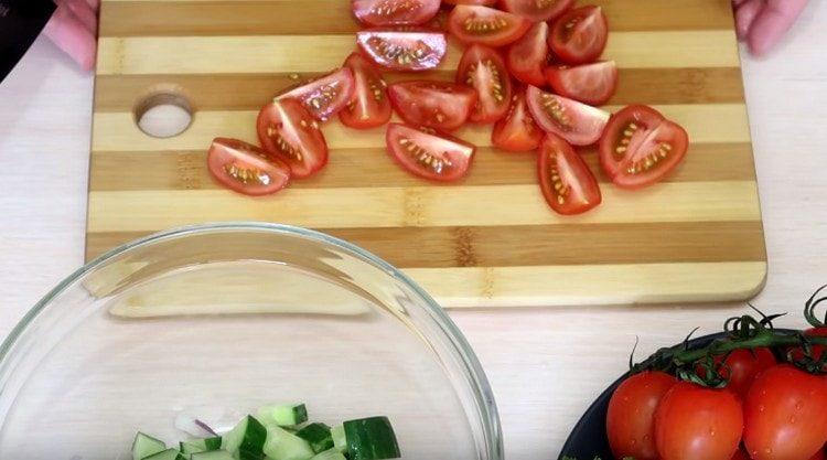 يتم قطع الطماطم الكرز إلى قطع.