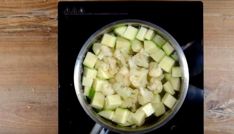 In kochendem Wasser die in Scheiben geschnittenen Blütenstände von Zucchini und Blumenkohl verteilen.