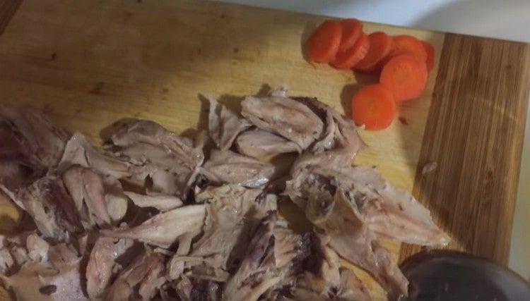 Нарежете морковите и месото на парчета.