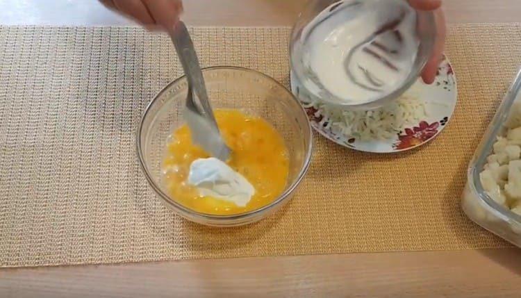 Aggiungi panna acida alla massa di uova.