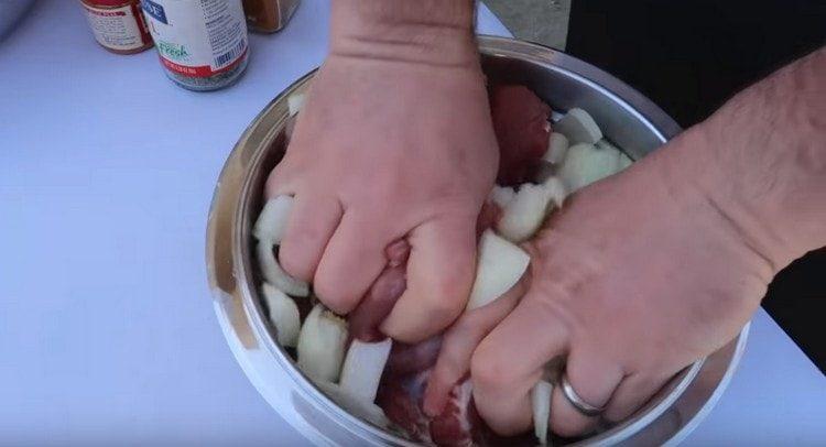 susmulkinkite svogūną ir suberkite į mėsą.