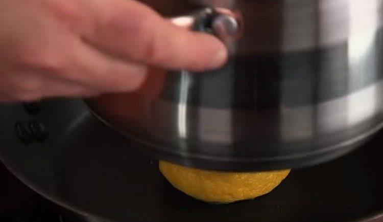 Friggiamo il limone in una padella asciutta, schiacciandolo, ad esempio, con una padella.