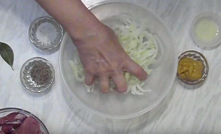 Нарязваме лука на половин пръстени и омесваме с ръце.