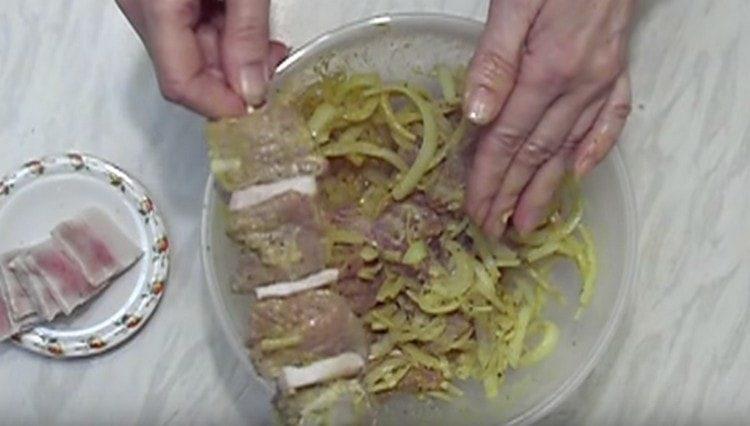 Mettiamo la carne sugli spiedini, alternandola con pezzi di pancetta affumicata.