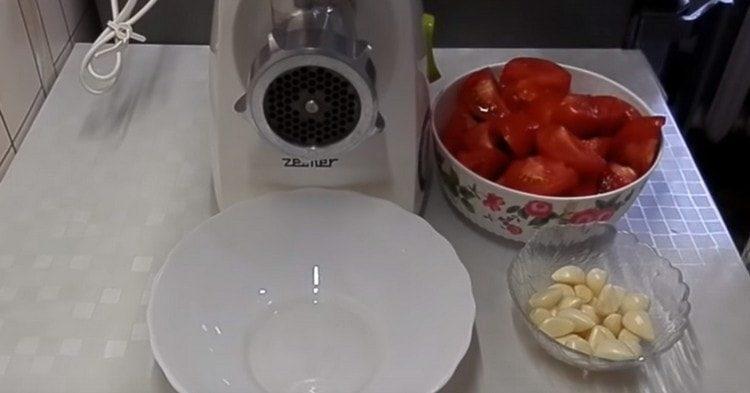 Нарязваме доматите на парчета, обелваме чесъна и ги прекарваме заедно през месомелачка.
