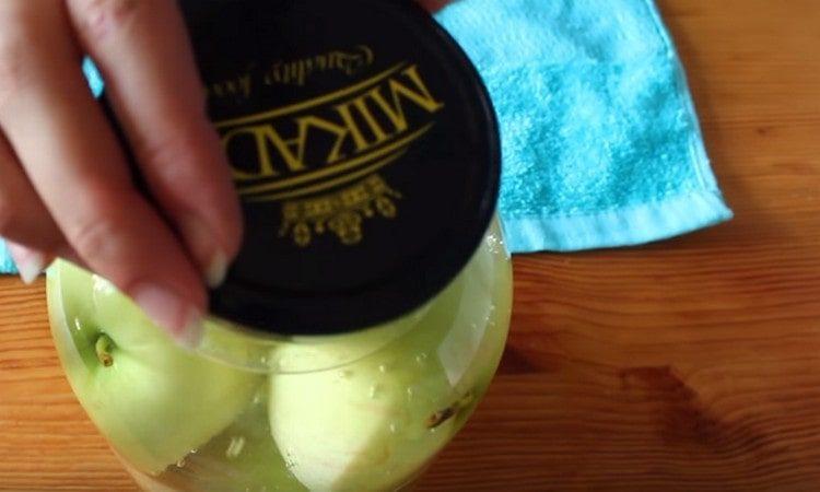 Decken Sie das Glas mit einem Deckel und lassen Sie die Äpfel in kochendem Wasser.