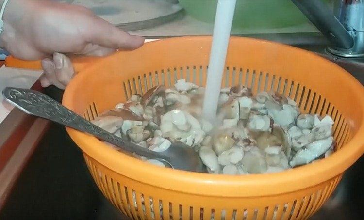 dann müssen Sie die Pilze in ein Sieb werfen und abspülen.