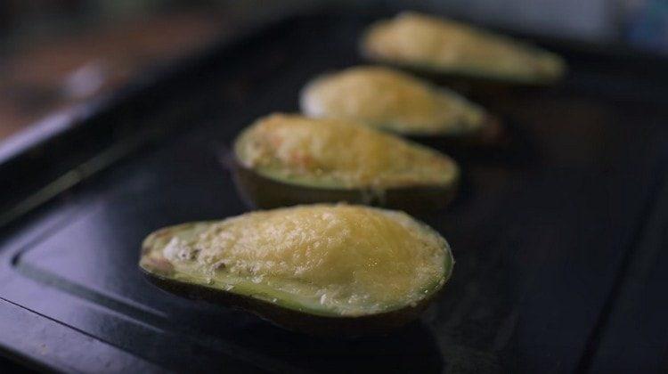 Cuocere un avocado sotto la griglia per diversi minuti.