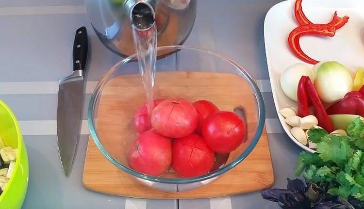 Wir schneiden Tomaten und gießen kochendes Wasser ein.