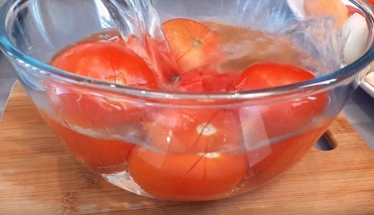 Kun vesi on kiehuva, täytä tomaatit kylmällä vedellä.