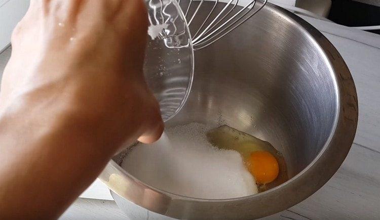 In der Rührschüssel die Eier schlagen, Zucker hinzufügen.