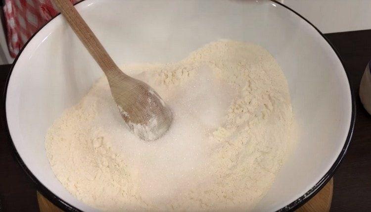Į miltus įpilkite druskos ir cukraus.