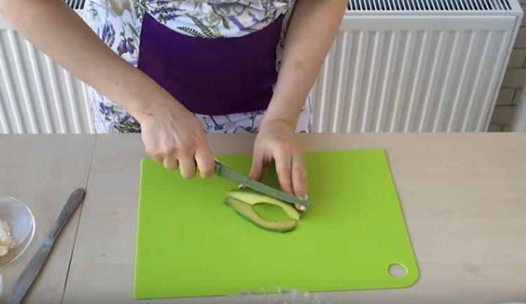 Wir schneiden Avocado in dünne Scheiben.