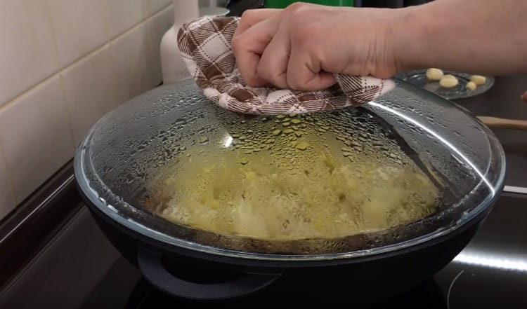 Προσθέστε λίγο νερό και καλύψτε το τηγάνι με ένα καπάκι.